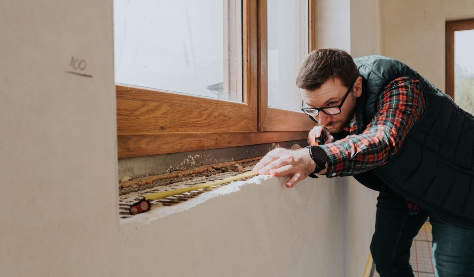carpenter measuring window ledge in new house rakr