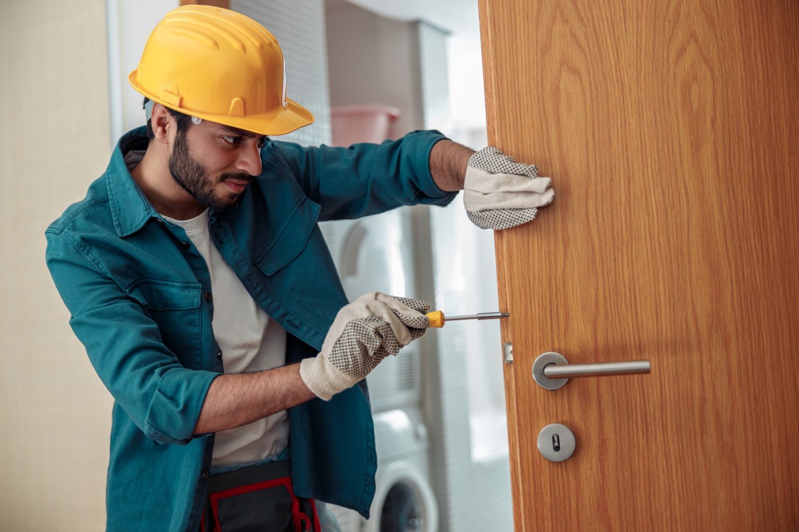 locksmith workman in uniform installing door knob hm5j.jpg