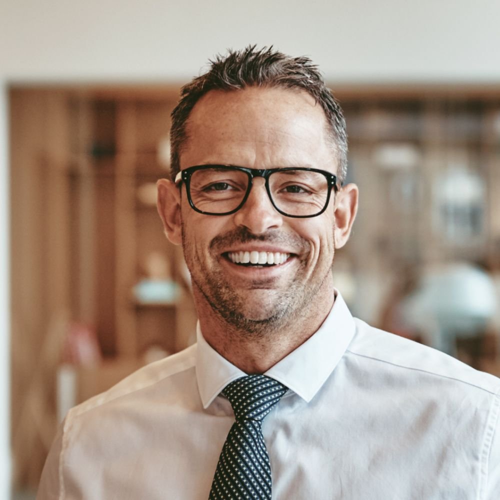 smiling mature businessman standing alone in an of y89vgbd 1.jpg