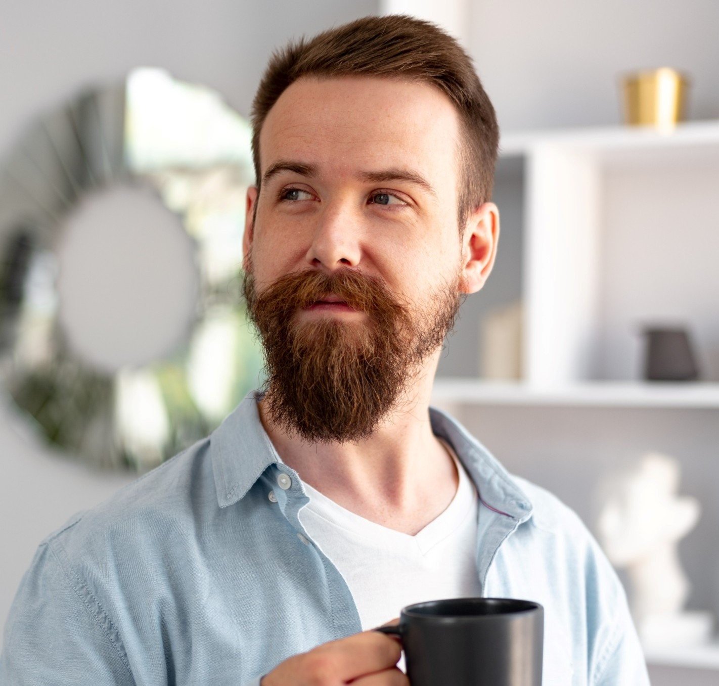 young bearded man smiling and drinking coff.jpg